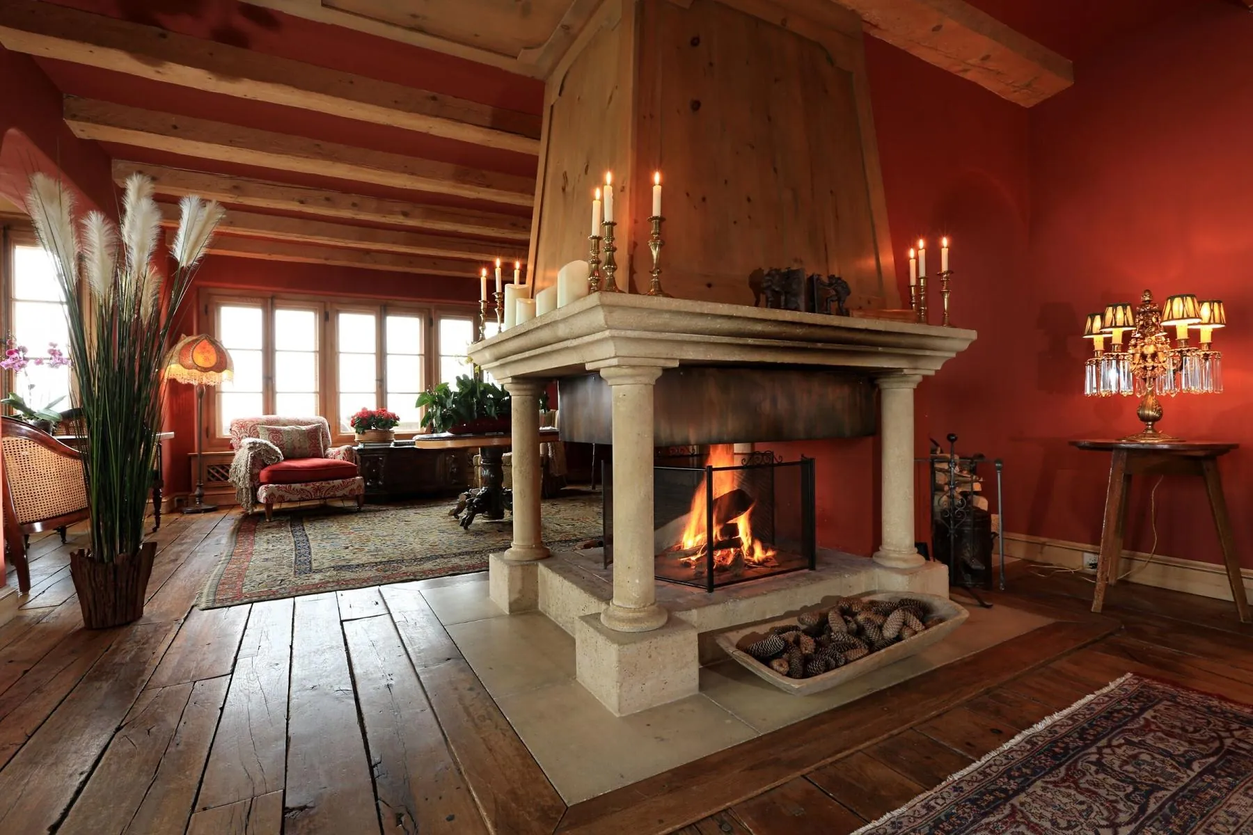 The pillared open fireplace in the drawing room of Chalet Kalem, Klosters