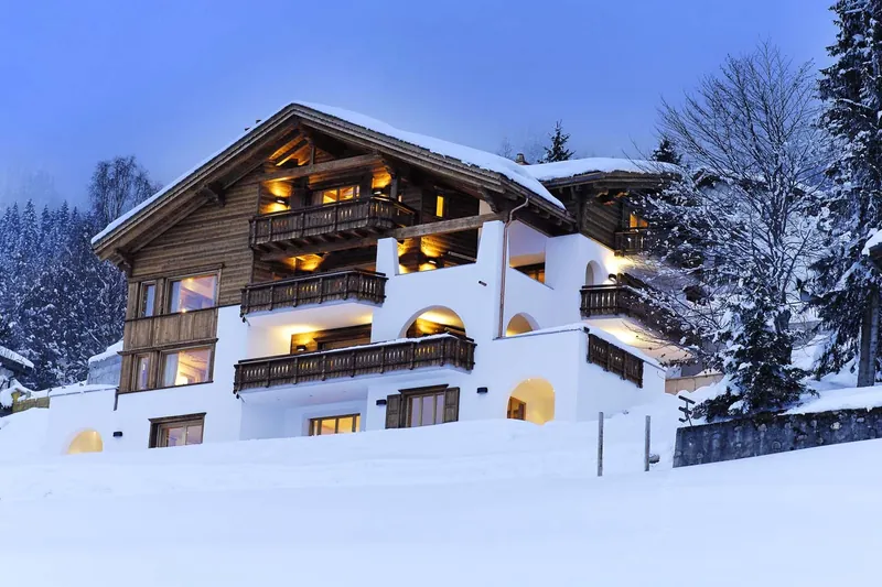Chalet Kolin under a blue sky in the snow, Klosters