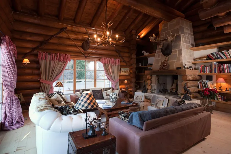 The log-built living room with an open fireplace at Chalet Magan, Davos