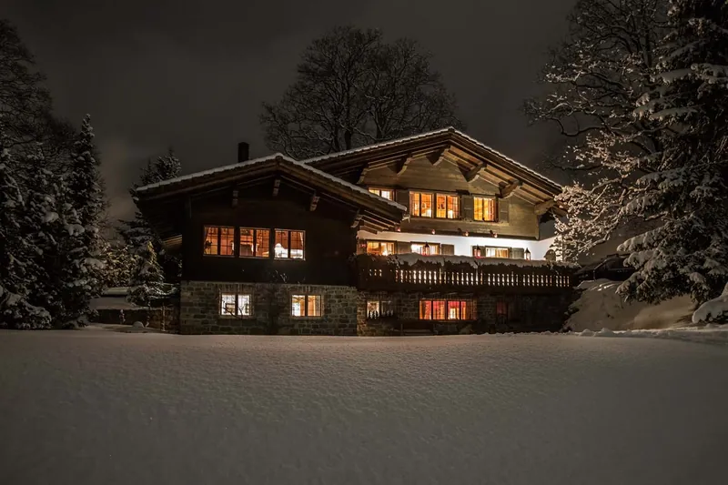 Chalet Valli at night with its windows glowing, Klosters